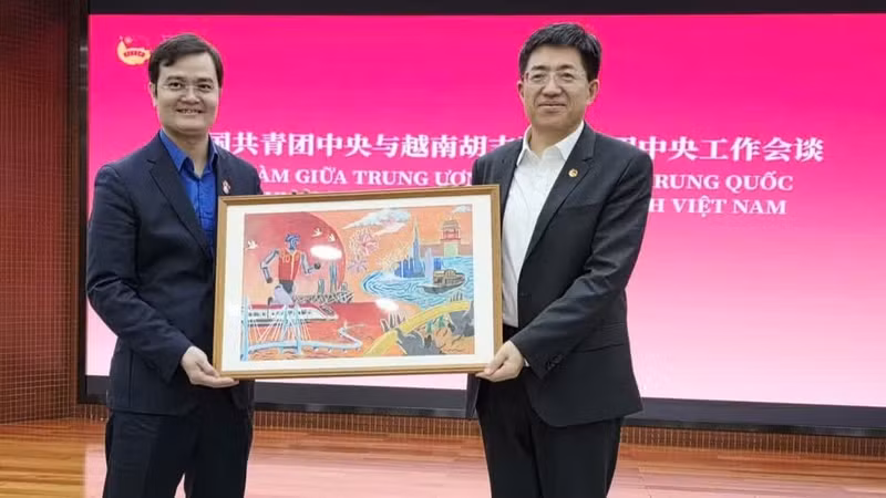阿东同志向裴光辉同志赠送由两国青少年共同绘制的2026年“红色研学之旅”活动画作。