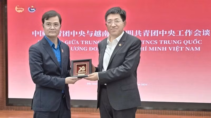 裴光辉同志向阿东同志赠送越南胡志明共青团第十三次全国代表大会纪念浮雕。