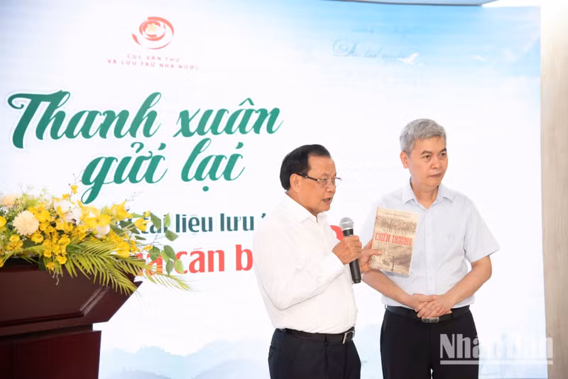 作为曾赴B干部的原越共中央政治局委员、原河内市委书记范光议向邓青雄局长转交《那里是战场》作品。