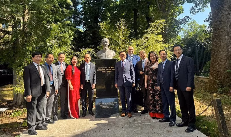 越南科学与技术翰林院代表团和越南驻奥地利共和国大使馆官员在位大使馆院子里的胡志明主席塑像前合影。