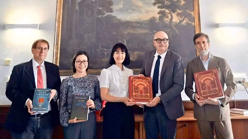 阮芳英大使向那不勒斯东方大学越南语系代表赠送书籍。（图片由越南驻意大利大使馆提供）