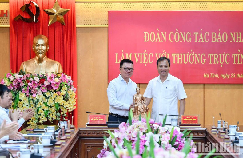 黎国明同志和黄忠勇同志互赠纪念品。