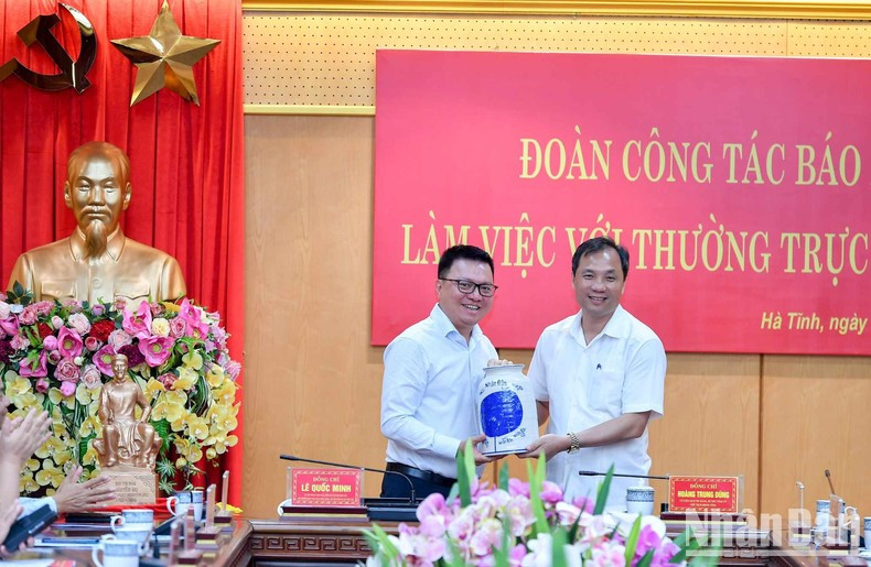 黎国明同志和黄忠勇同志互赠纪念品。