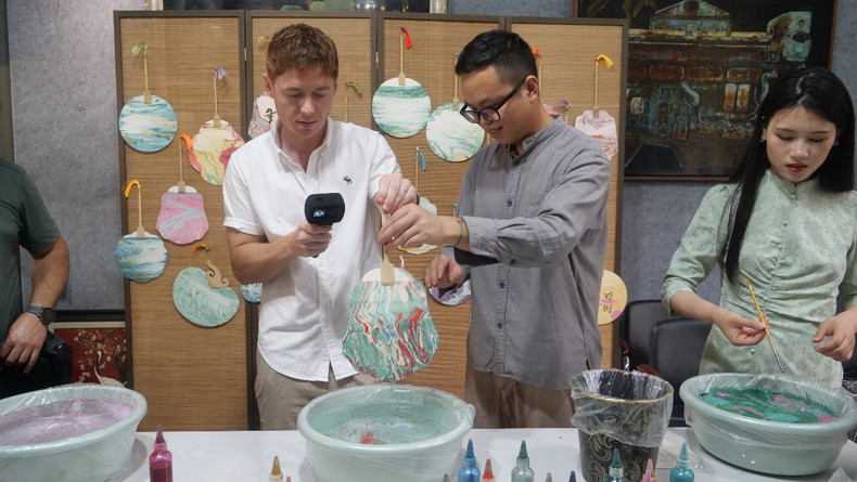 体验漆扇成画。