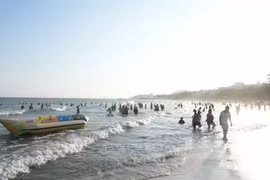 游客在美奈海边尽享清新的空气、湛蓝的海水和温暖明媚的阳光。