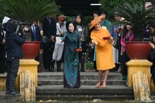比利时王后玛蒂尔德和越南国家主席夫人阮氏明月参观高脚屋正前方的胡伯伯鱼塘并喂鱼。