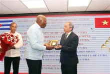 胡志明市友好组织联合会主席杜越何向古巴共产党中央政治局委员、国家副主席萨尔瓦多•瓦尔德斯•梅萨赠送纪念品。（图片来源：越通社）