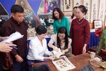 越南政府总理夫人同河内市东盟妇女小组体验东湖民间画印制。 （图片来源：越通社）