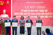 中央机关党委常委、宣教部主任何氏庄同志向人民报社党委党员颁发“致力于中央机关党委建设事业”纪念章。成达 摄