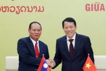 越共公安部部长梁三光大将和老挝公安部部长维莱·拉坎丰握手。