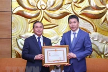 老挝驻越南大使森菲特•洪邦光(左)荣获“致力于各民族和平友谊” 纪念章。