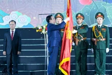 国会主席王廷惠把勋章佩戴在传统旗帜上。