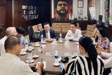 越南《人民报》社总编辑、越共中央宣教部副部长、越南新闻工作者协会主席黎国明与《格拉玛报》社领导举行工作会议。 （图片来源：梅芳/越通社）