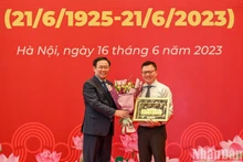 国会主席王廷惠向越南《人民报》社总编辑、越南新闻工作者协会主席黎国明赠送纪念品。（维灵 摄）