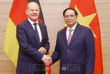 越南政府总理范明正与德国总理朔尔茨握手。