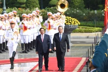 范明正总理邀请李强总理检阅越南人民军仪仗队。