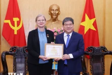胡志明国家政治学院常务副院长阮维北副教授向瑞典驻越特命全权大使安·马威授予“致力于政治理论培训事业”纪念章。