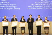 越老友好协会中央委员会主席阮得荣向老越友好协会中央委员会会员授予越南国家友谊勋章。（图片来源：越通社）