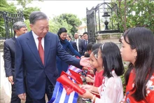 越共中央总书记、国家主席苏林和夫人与旅居古巴越南儿童。（图片来源：越通社）