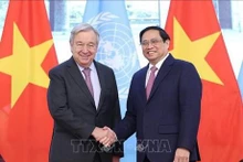 越南政府总理范明正与联合国秘书长安东尼奥·古特雷斯亲切握手。(图片来源:越通社)