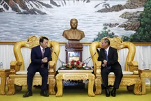 越南公安部副部长梁三光上将与老挝政府副总理、公安部部长维莱·拉坎丰。（图片来源：越通社）