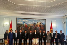 越南国会副主席阮克定（左六）与吉尔吉斯斯坦议会副议长伊萨耶娃（左七）以及双方代表合影。（图片来源：越通社）