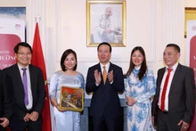 越南国家主席武文赏向旅居英国越南人赠送礼物。（图片来源：越通社）