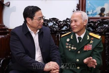 政府总理范明正（左）与人民武装力量英雄邓非赏亲切交谈。