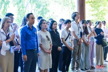 参加“2023年越南夏令营”的海外越侨青年在同禄三岔路口历史遗迹，向各位年轻女烈士献花进香。