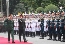 阮新疆上将和西萨瓦特上将检阅越南人民军仪仗队。（图片来源：越通社）