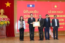 老挝占巴塞省代表团向广治省授予老挝国家主席一级劳动勋章。（图片来源：越通社）