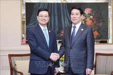 越南国家主席梁强（右）会见中国香港特别行政区行政长官李家超。（图片来源：越通社）