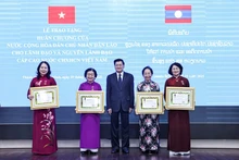 老挝国家主席通伦·西苏里向越南国家副主席武氏映春及几位前任副主席颁授一级自由勋章。（图片来源：qdnd.vn）