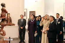 越共中央总书记苏林夫人吴芳璃与法国总统夫人布丽吉特·马克龙参观越南美术博物馆。（图片来源：越通社）
