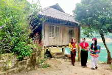 当地人民向游客介绍和平省陀北县石卑社区旅游村。