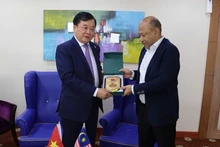 越南国防部副部长黄春战上将向马来西亚国防部副秘书长雅尼赠送纪念品。（图片来源：qdnd.vn）