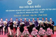 阮伯雄大使和老挝工贸部副部长向第三届（2022-2027年任期）在老挝越南企业协会执委会赠送鲜花。