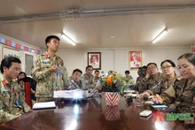 范文雄少校（左二）同蒙古单位分享疫情防控经验。（图片来源：人民军队报）
