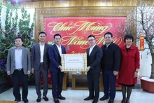 《人民报》社总编辑黎国明（右三）向第325师干部、战士赠送礼物。