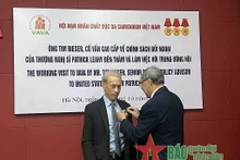 阮文赢上将向蒂姆·里瑟先生授予致力于橙剂受害者纪念章。（图片来源：人民军队报）