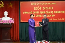 黎明兴同志向何氏娥同志授予决定书。