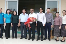 越南劳动总联合会常务副主席蔡秋昌和老挝中央工会联合会高级代表团合影。（图片来源：laodong.vn）