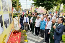 各位代表参观图片展。（图片来源：越通社）