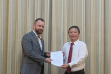 胡志明市人民委员会副主席杨英德和保罗·哈金斯先生。（图片来源：西宫解放报）