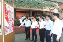 宁平省干部和人民参观纪念胡志明主席发出“爱国竞赛”号召75周年的宣传画展。（图片来源：明光 摄）