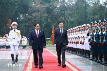 越南政府总理范明正与新加坡总理黄循财共同检阅仪仗队。（图片来源：越通社）