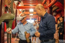 游客在文庙-国子监体验通过虚拟现实技术写书法。 