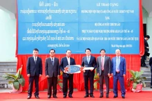 越南公安部副部长梁三光上将向老挝公安部移交20辆汽车和30辆摩托车。