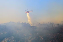 直升机参加希腊雅典附近帕尼萨山的森林消防行动。 （图片来源：路透社）