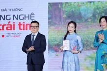 人民报社总编辑黎国明和越通社社长武越庄(右)颁发奖状。